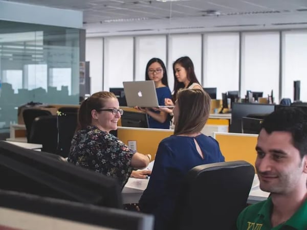 Employees chat in an office during a new employee orientation in 2024.